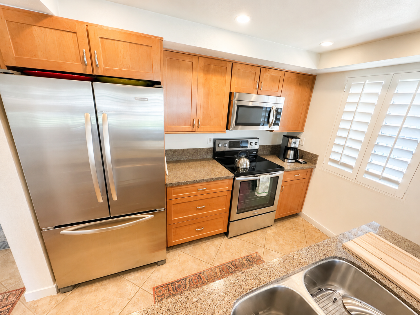 Updated kitchen with stainless steel appliances and warm wood cabinetry
