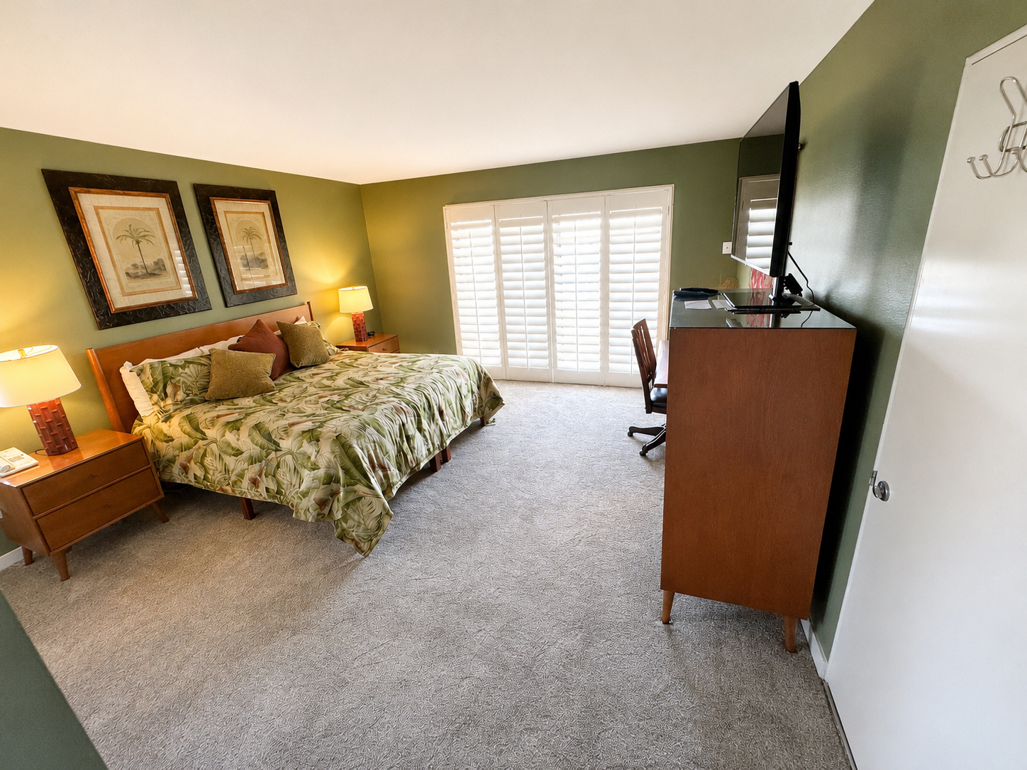 Primary bedroom with plantation shutters and desk area